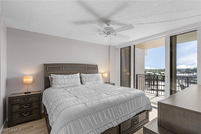 180 Seaview Ct Unit 612, Marco Island, FL 34145 - bedroom featuring access to outside, light wood-type flooring, a ceiling fan, a textured ceiling, and a wall of windows