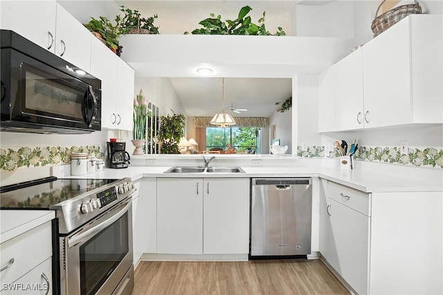 800 New Waterford Dr Unit A202, Naples, FL 34104 - kitchen featuring stainless steel appliances, light wood finished floors, light countertops, white cabinetry, and decorative light fixtures