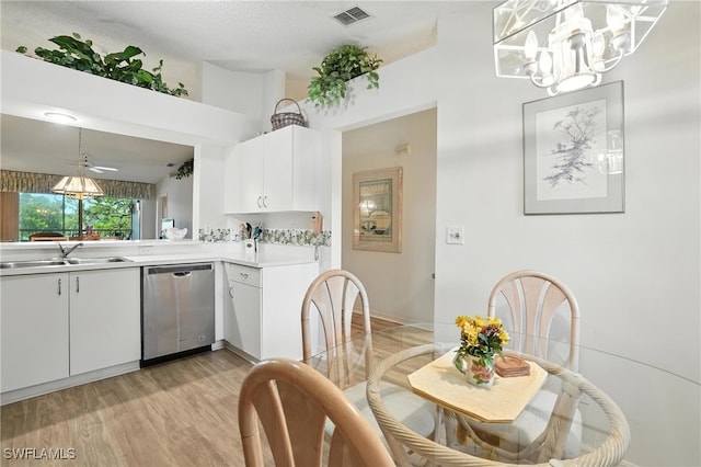 800 New Waterford Dr Unit A202, Naples, FL 34104 - kitchen with stainless steel dishwasher, light countertops, light wood-style flooring, and white cabinetry