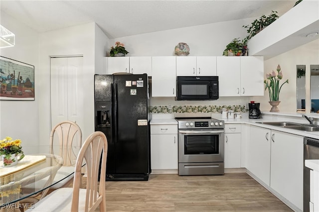 800 New Waterford Dr Unit A202, Naples, FL 34104 - kitchen featuring black appliances, light countertops, light wood-type flooring, and white cabinets