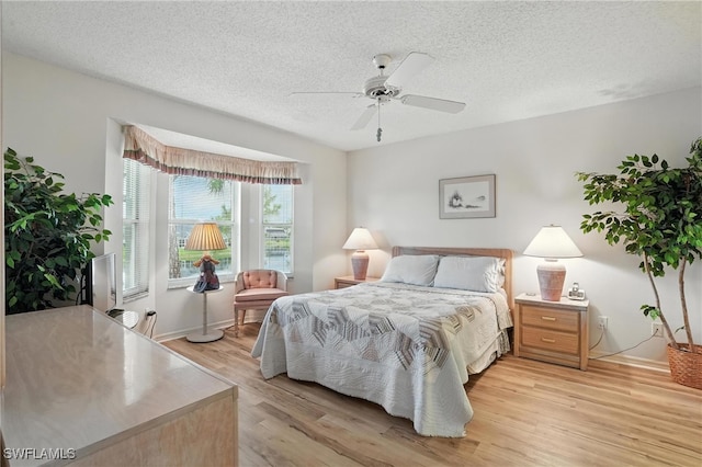800 New Waterford Dr Unit A202, Naples, FL 34104 - bedroom featuring light wood-style flooring, a textured ceiling, and a ceiling fan