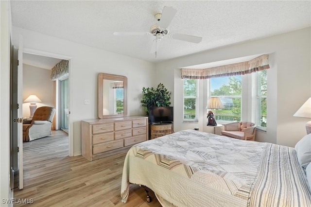 800 New Waterford Dr Unit A202, Naples, FL 34104 - bedroom with light wood-style flooring, a ceiling fan, and a textured ceiling