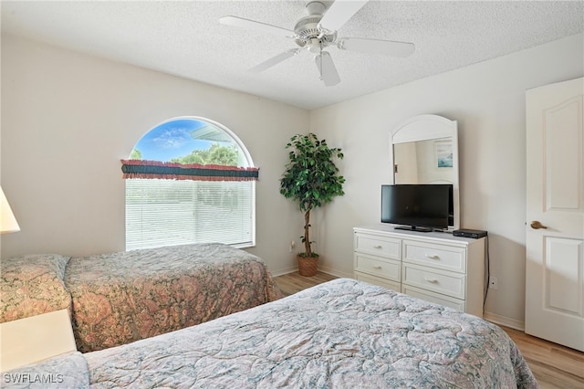 800 New Waterford Dr Unit A202, Naples, FL 34104 - bedroom with light wood finished floors, a textured ceiling, and ceiling fan