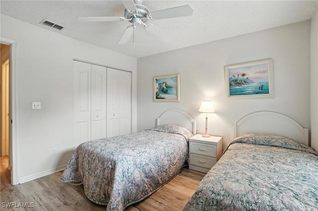 800 New Waterford Dr Unit A202, Naples, FL 34104 - bedroom with light wood-style floors, a closet, a textured ceiling, and ceiling fan