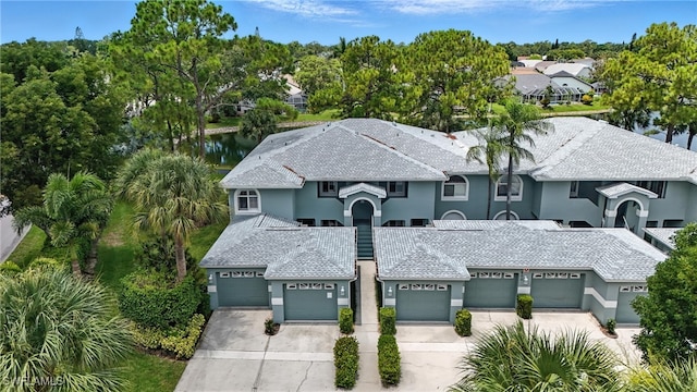800 New Waterford Dr Unit A202, Naples, FL 34104 - view of front facade featuring driveway, a garage, stucco siding, and a water view