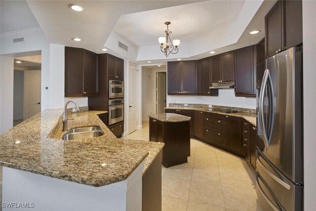 24011 Via Castella Dr Unit 2402, Bonita Springs, FL 34134 - kitchen with freestanding refrigerator, under cabinet range hood, a peninsula, light stone counters, and dark brown cabinets
