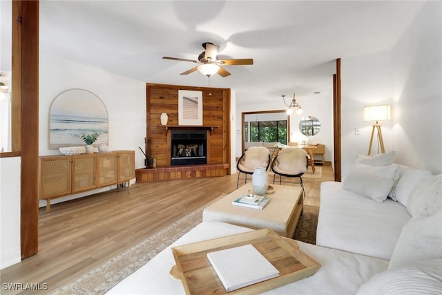 3110 10th Ave SE, Naples, FL 34117 - living room with ceiling fan, light wood-style floors, and a fireplace with raised hearth