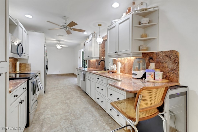 3110 10th Ave SE, Naples, FL 34117 - kitchen with stainless steel appliances, a ceiling fan, tasteful backsplash, open shelves, and light stone counters