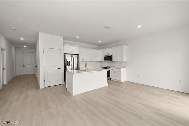 9013 Largo Cir, Labelle, FL 33935 - kitchen with appliances with stainless steel finishes, light wood finished floors, recessed lighting, white cabinets, and light countertops