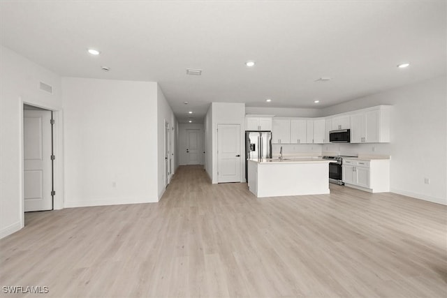 9013 Largo Cir, Labelle, FL 33935 - kitchen featuring stainless steel appliances, open floor plan, recessed lighting, white cabinets, and light wood-style flooring