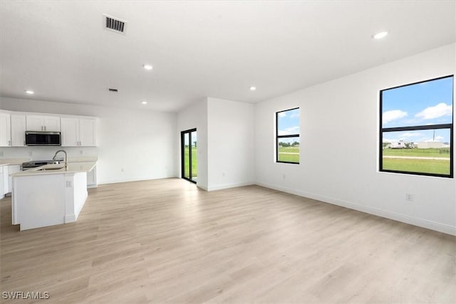 9013 Largo Cir, Labelle, FL 33935 - unfurnished living room with plenty of natural light, recessed lighting, and light wood-type flooring