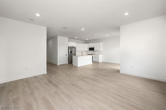 9013 Largo Cir, Labelle, FL 33935 - unfurnished living room featuring recessed lighting and light wood-type flooring