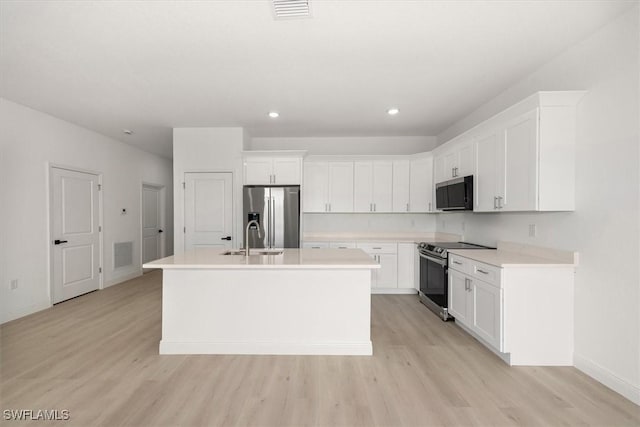 9013 Largo Cir, Labelle, FL 33935 - kitchen with stainless steel appliances, a center island with sink, light wood-style floors, and recessed lighting