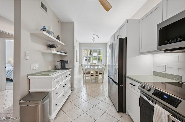2370 Magnolia Ave Unit 6807, Naples, FL 34112 - kitchen featuring stainless steel appliances, open shelves, light tile patterned flooring, light countertops, and decorative backsplash