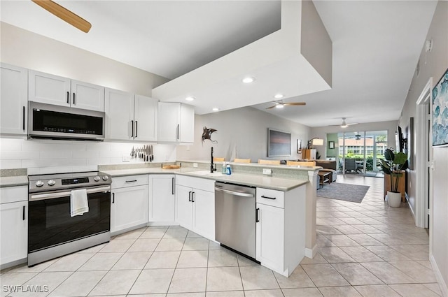 2370 Magnolia Ave Unit 6807, Naples, FL 34112 - kitchen with a ceiling fan, stainless steel appliances, a peninsula, open floor plan, and light countertops