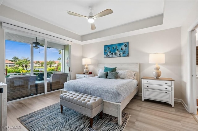 2370 Magnolia Ave Unit 6807, Naples, FL 34112 - bedroom featuring access to exterior, light wood-style floors, a tray ceiling, and ceiling fan