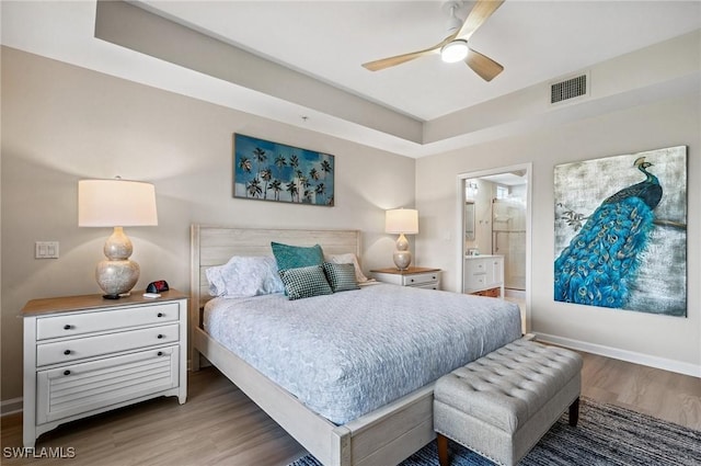 2370 Magnolia Ave Unit 6807, Naples, FL 34112 - bedroom with wood finished floors, connected bathroom, a raised ceiling, and ceiling fan