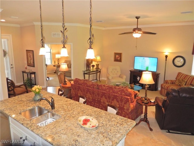 11775 Avingston Ter, Fort Myers, FL 33913 - kitchen featuring open floor plan, a ceiling fan, light stone counters, ornamental molding, and an island with sink