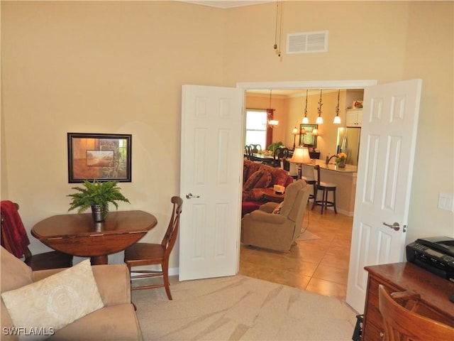 11775 Avingston Ter, Fort Myers, FL 33913 - dining area with a chandelier, light tile patterned floors, a high ceiling, and light colored carpet