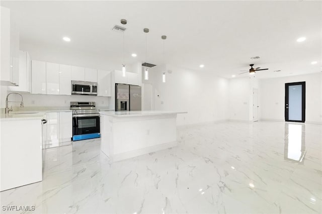 2803 E 13th St, Lehigh Acres, FL 33972 - kitchen featuring stainless steel appliances, white cabinets, recessed lighting, a kitchen island, and pendant lighting