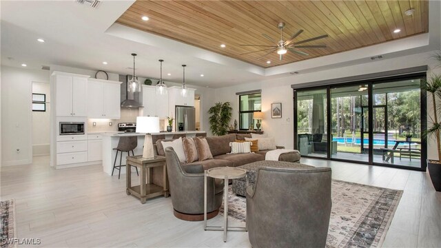 1030 22nd Ave NE, Naples, FL 34120 - living area featuring a tray ceiling, wood ceiling, a ceiling fan, light wood-style floors, and recessed lighting