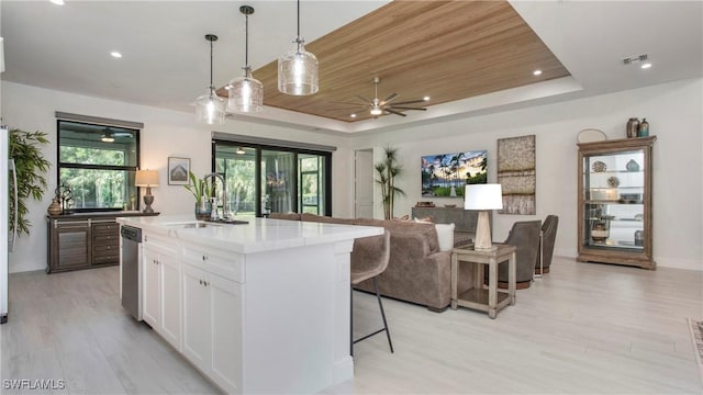 1030 22nd Ave NE, Naples, FL 34120 - kitchen with a ceiling fan, white cabinetry, a kitchen breakfast bar, open floor plan, and a raised ceiling