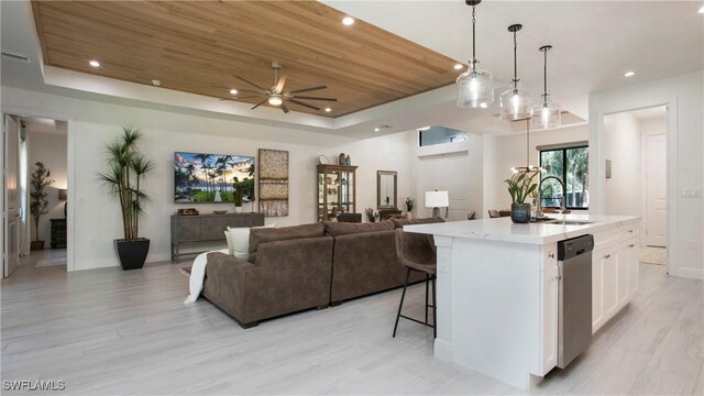 1030 22nd Ave NE, Naples, FL 34120 - kitchen featuring a tray ceiling, stainless steel dishwasher, white cabinetry, open floor plan, and recessed lighting