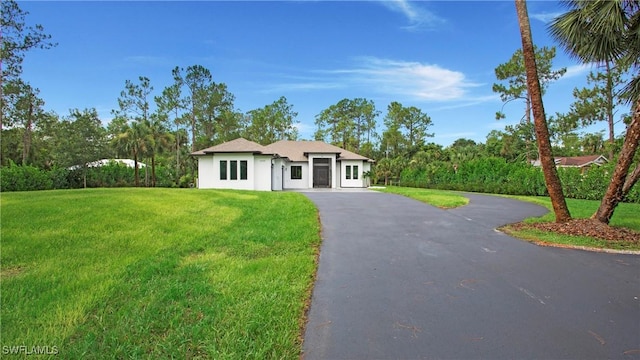 1030 22nd Ave NE, Naples, FL 34120 - view of front of property featuring a front lawn, asphalt driveway, and stucco siding