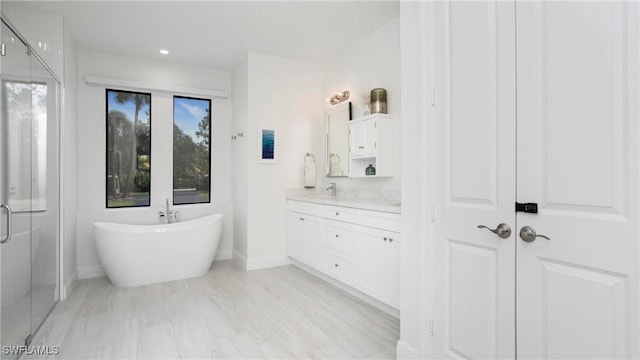 1030 22nd Ave NE, Naples, FL 34120 - full bathroom featuring vanity, a soaking tub, a shower stall, and recessed lighting