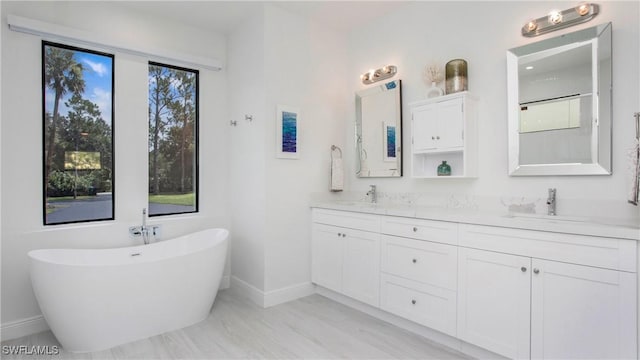 1030 22nd Ave NE, Naples, FL 34120 - full bathroom featuring double vanity, a freestanding bath, plenty of natural light, and a shower