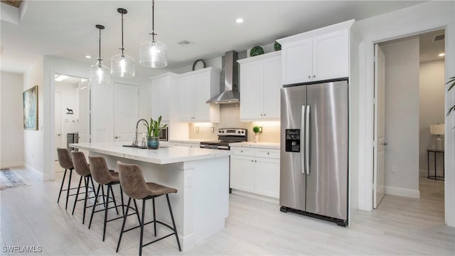 1030 22nd Ave NE, Naples, FL 34120 - kitchen with stainless steel appliances, wall chimney exhaust hood, a center island with sink, decorative backsplash, and recessed lighting