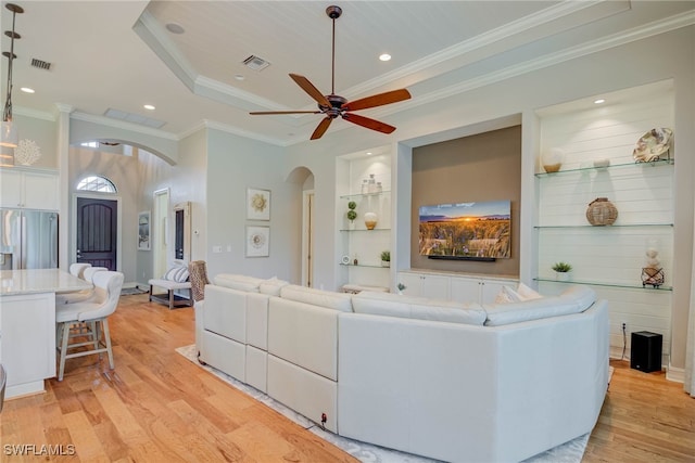11330 Hidalgo Ct, Fort Myers, FL 33912 - living area with arched walkways, a ceiling fan, light wood-type flooring, ornamental molding, and a raised ceiling