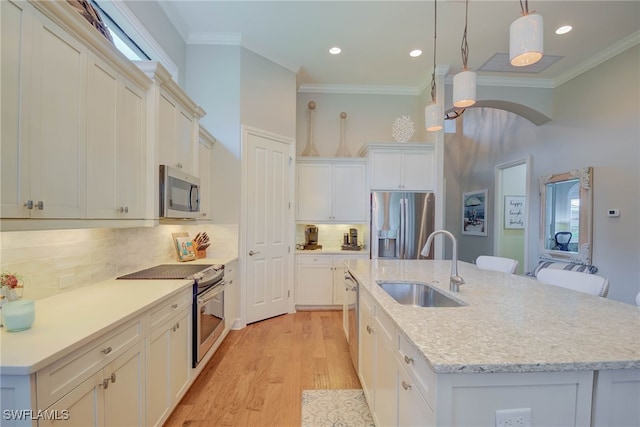 11330 Hidalgo Ct, Fort Myers, FL 33912 - kitchen with appliances with stainless steel finishes, an island with sink, ornamental molding, light wood-type flooring, and pendant lighting
