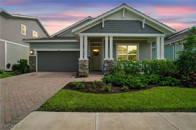 3387 Pilot Cir, Naples, FL 34120 - craftsman house featuring an attached garage, decorative driveway, a porch, and stone siding