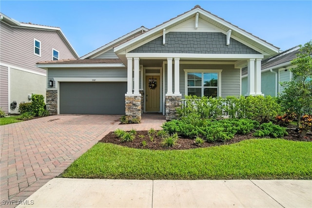 3387 Pilot Cir, Naples, FL 34120 - craftsman-style home featuring an attached garage, decorative driveway, and covered porch