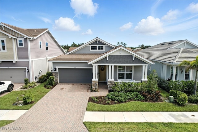 3387 Pilot Cir, Naples, FL 34120 - craftsman-style house featuring decorative driveway, a garage, a porch, and stone siding