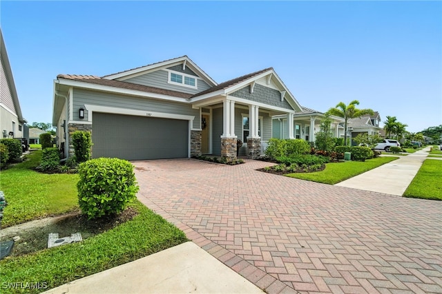 3387 Pilot Cir, Naples, FL 34120 - craftsman-style house with decorative driveway, a garage, stone siding, a porch, and a front yard