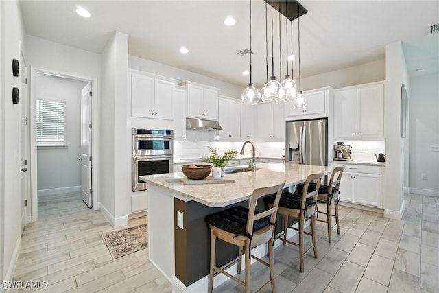 3387 Pilot Cir, Naples, FL 34120 - kitchen featuring stainless steel appliances, decorative backsplash, under cabinet range hood, white cabinets, and recessed lighting