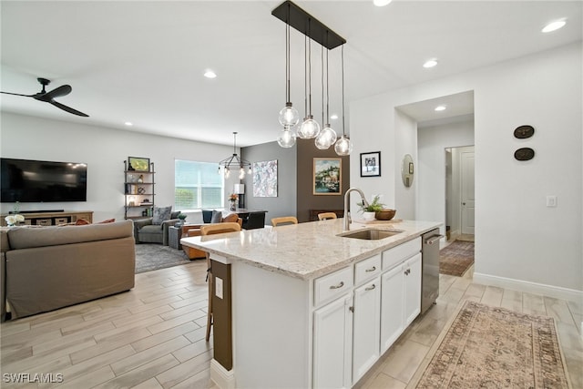 3387 Pilot Cir, Naples, FL 34120 - kitchen featuring dishwasher, white cabinets, a kitchen island with sink, light stone countertops, and recessed lighting
