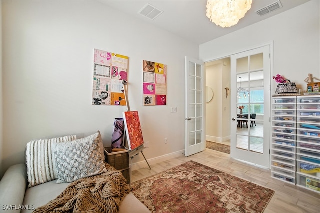 3387 Pilot Cir, Naples, FL 34120 - sitting room featuring a chandelier, french doors, and wood finished floors