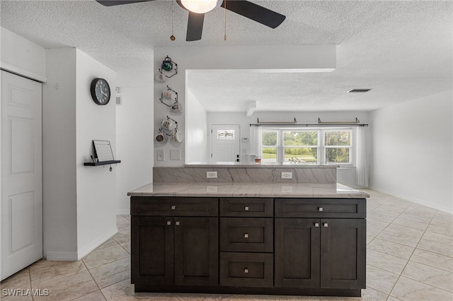 4811 Shady River Ln, Fort Myers, FL 33905 - kitchen with a textured ceiling, ceiling fan, a peninsula, dark brown cabinets, and light tile patterned floors
