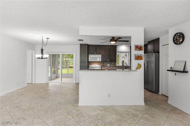 4811 Shady River Ln, Fort Myers, FL 33905 - kitchen with white microwave, stainless steel fridge, a chandelier, dark brown cabinetry, and ceiling fan