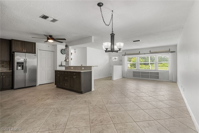 4811 Shady River Ln, Fort Myers, FL 33905 - kitchen with stainless steel fridge, a textured ceiling, a chandelier, open floor plan, and dark brown cabinetry