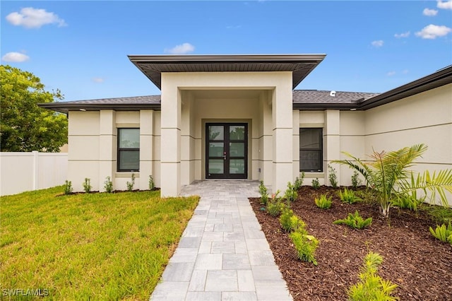 1117 SW Trafalgar Pkwy, Cape Coral, FL 33991 - view of exterior entry featuring french doors, stucco siding, and a shingled roof