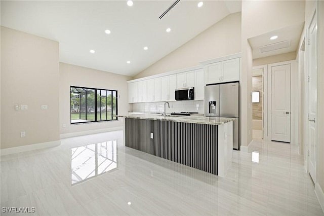 1117 SW Trafalgar Pkwy, Cape Coral, FL 33991 - kitchen with stainless steel appliances, white cabinets, an island with sink, recessed lighting, and tasteful backsplash