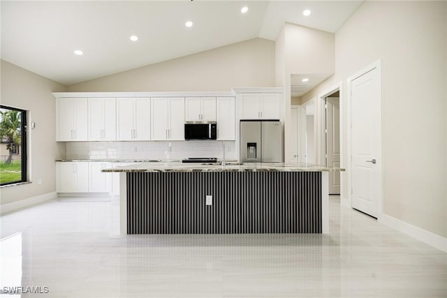 1117 SW Trafalgar Pkwy, Cape Coral, FL 33991 - kitchen with appliances with stainless steel finishes, white cabinets, a center island with sink, decorative backsplash, and lofted ceiling