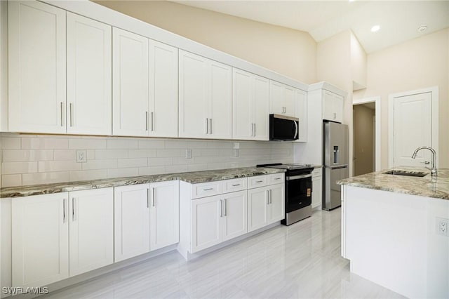 1117 SW Trafalgar Pkwy, Cape Coral, FL 33991 - kitchen with stainless steel appliances, tasteful backsplash, light stone counters, white cabinets, and recessed lighting