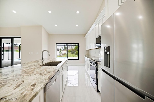 1117 SW Trafalgar Pkwy, Cape Coral, FL 33991 - kitchen featuring stainless steel appliances, white cabinets, recessed lighting, light stone countertops, and tasteful backsplash