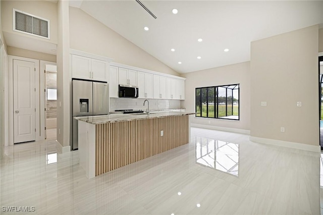 1328 SW 22nd Pl, Cape Coral, FL 33991 - kitchen with stainless steel appliances, a kitchen island with sink, backsplash, light tile patterned floors, and light stone countertops