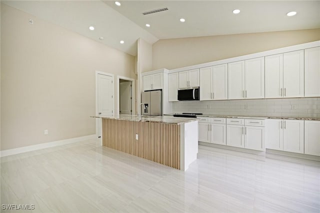 1328 SW 22nd Pl, Cape Coral, FL 33991 - kitchen featuring appliances with stainless steel finishes, high vaulted ceiling, a kitchen island with sink, tasteful backsplash, and light stone countertops